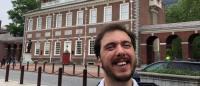 man in wheelchair outside with buildings behind him